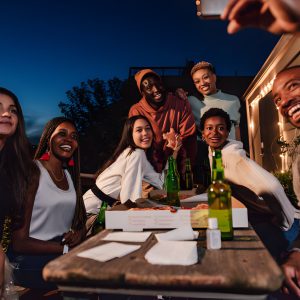 Three young black adults enjoying a garden dinner party stock photo